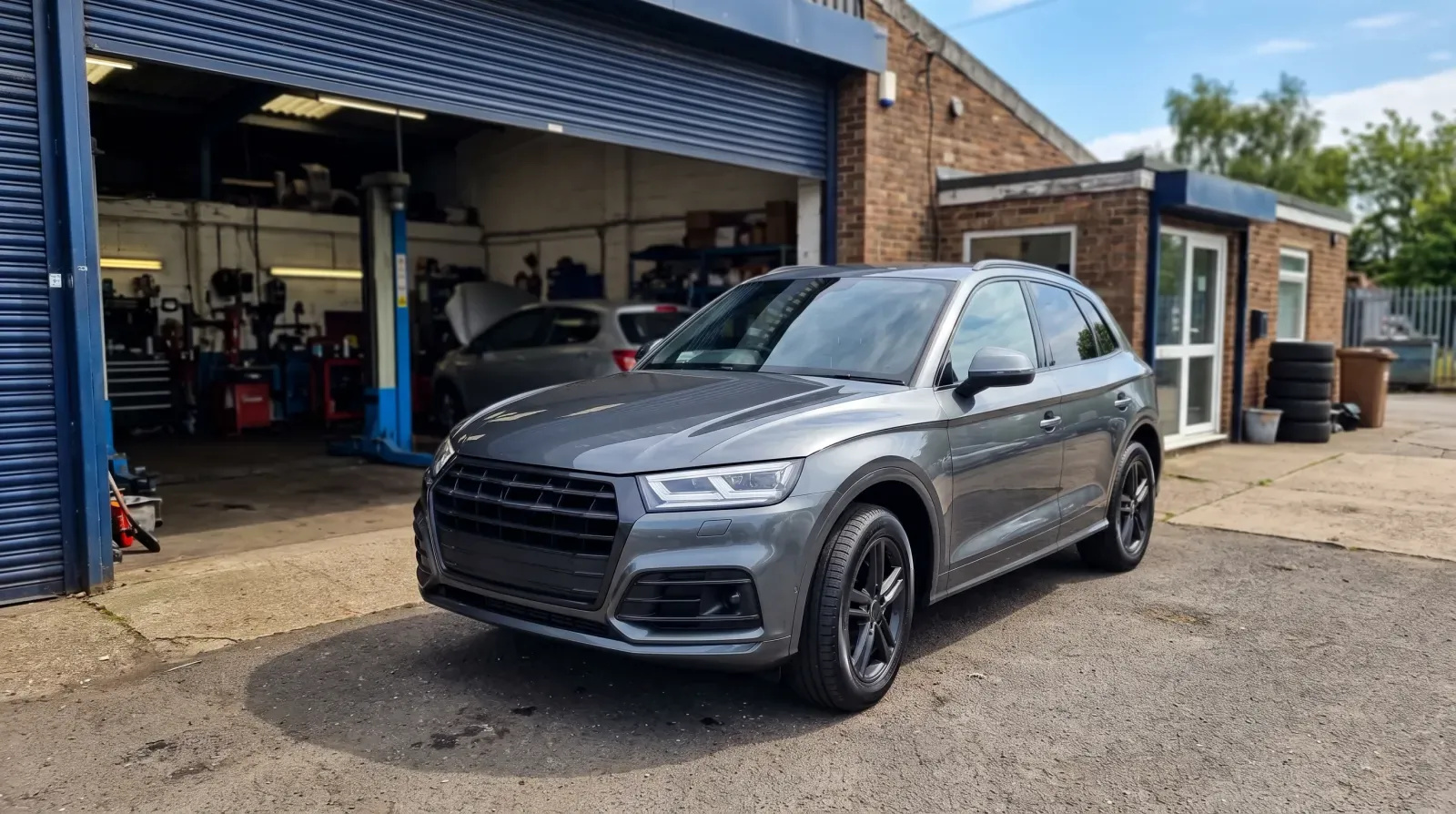 A grey SUV outside the workshop, ready to go back