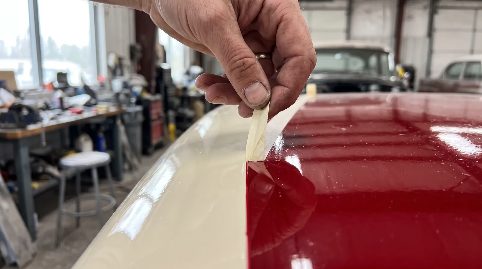 Fine-line tape being peeled off a fresh two-tone split, red against cream