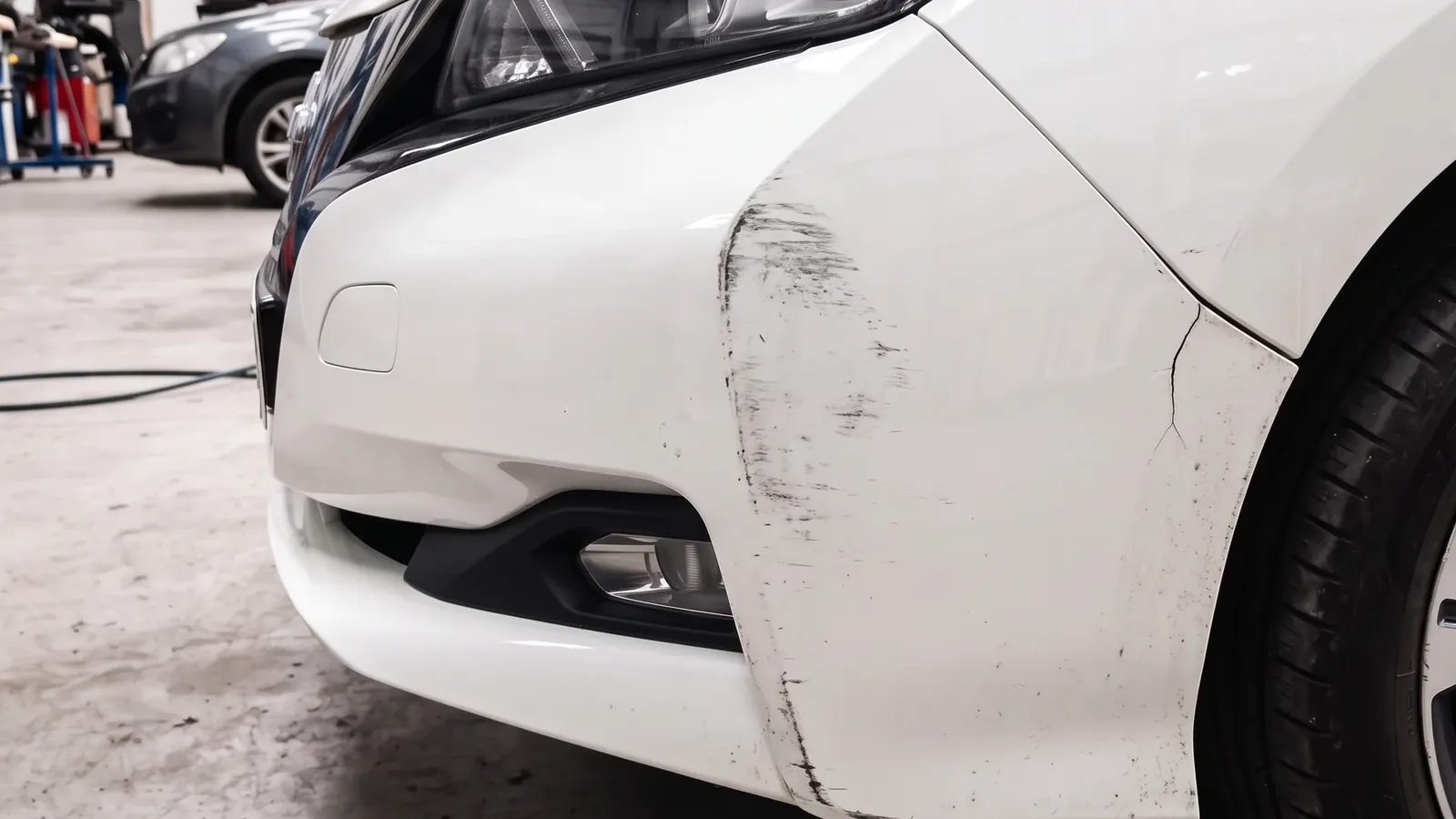 The same white bumper corner, scuffed and cracked before and smooth and painted after, before