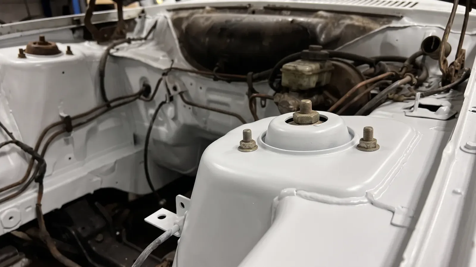 A front suspension turret in an Escort's engine bay, after