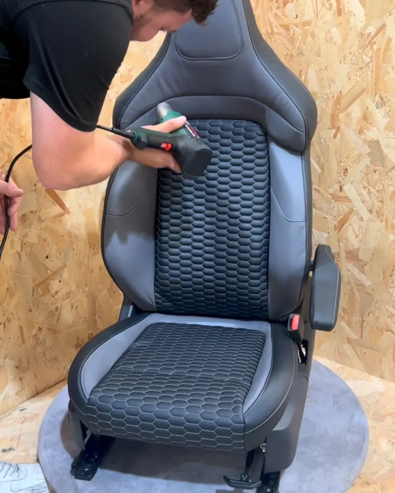 A DK Schweizer fitter working a black leather sports seat with honeycomb centres