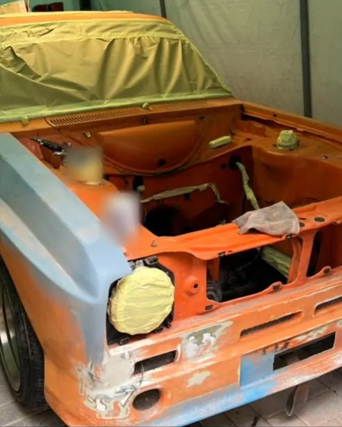 An Escort shell in orange with its headlamp bowl and windscreen masked